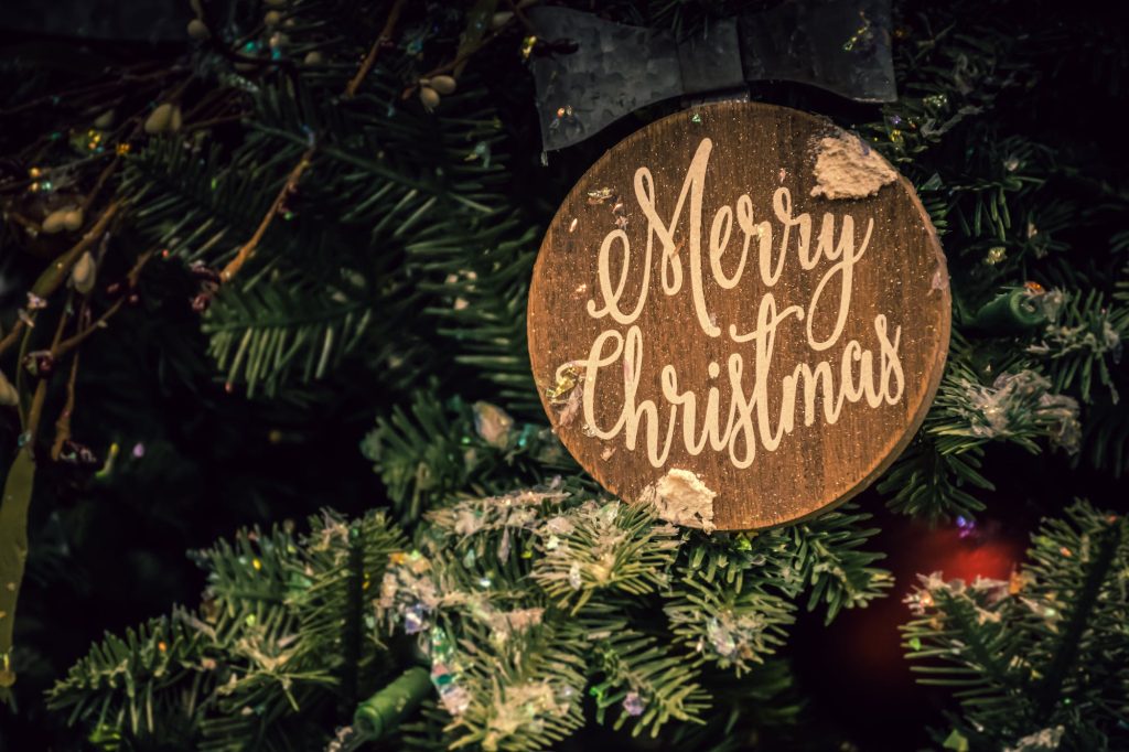 merry christmas sign on a tree in carved wood