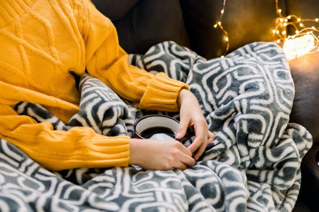 girl-in-a-couch-staying-warm-and-cozy-with-a-blanket