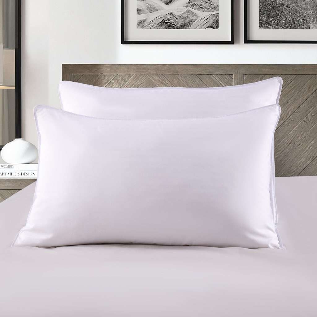 White pillows on modern bed with artwork above.