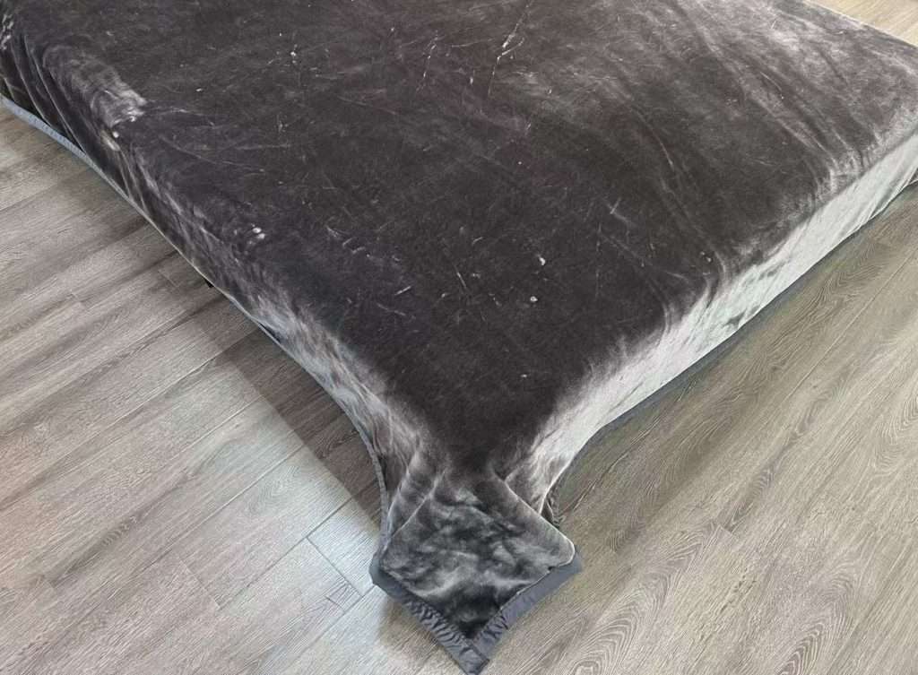 Grey velvet blanket on wooden floor