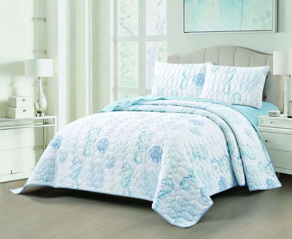 Bright bedroom with blue seashell-patterned quilted bedding