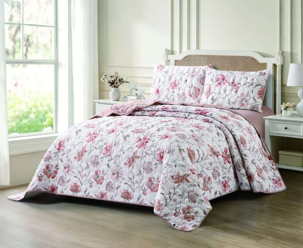 Sunlit bedroom with pink floral quilted bedding